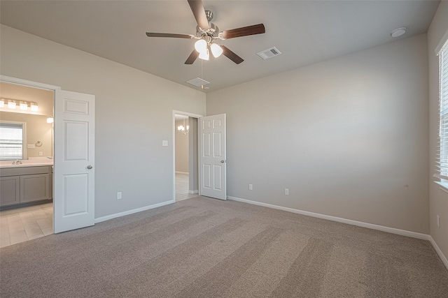 unfurnished bedroom with ceiling fan, sink, ensuite bathroom, and light carpet