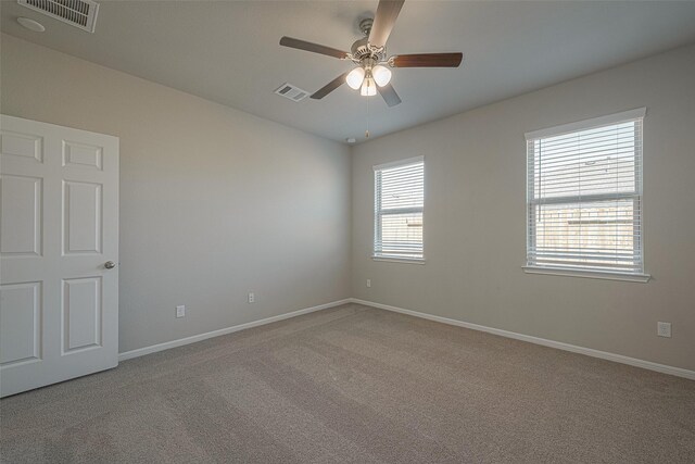 carpeted spare room with ceiling fan