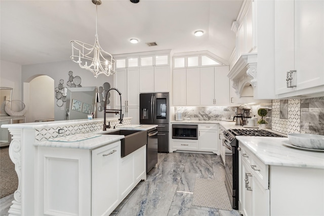 kitchen with decorative backsplash, stainless steel appliances, decorative light fixtures, a center island with sink, and white cabinetry