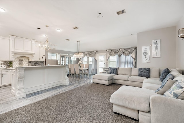 living room featuring a chandelier, plenty of natural light, and sink