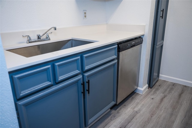 kitchen with dishwasher, light wood-type flooring, blue cabinets, and sink