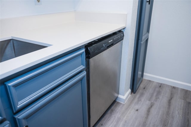 kitchen featuring dishwasher, light hardwood / wood-style flooring, and blue cabinets