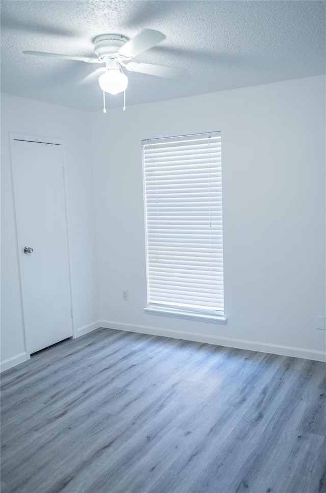 empty room with hardwood / wood-style floors, plenty of natural light, and ceiling fan