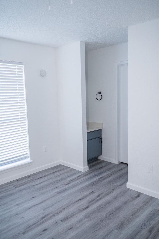 unfurnished room with wood-type flooring and a textured ceiling