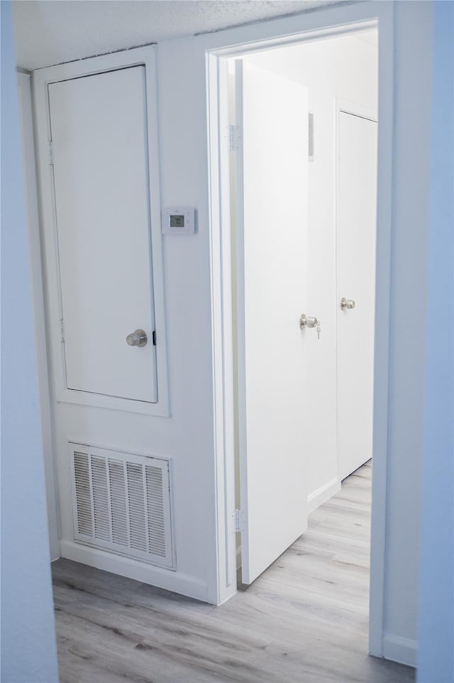 hallway with light hardwood / wood-style floors