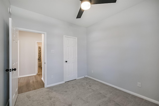 unfurnished bedroom featuring ceiling fan, light carpet, and a closet