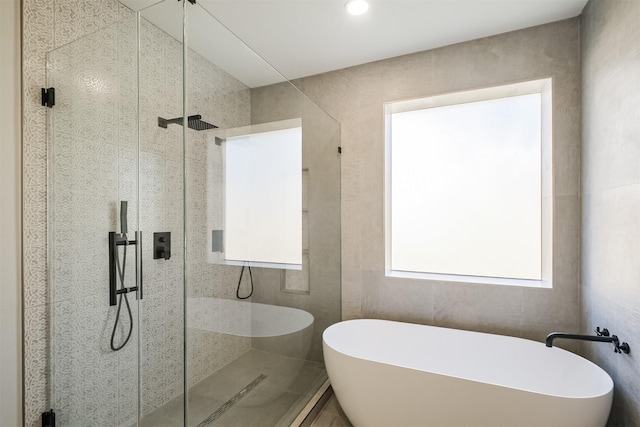 bathroom featuring shower with separate bathtub