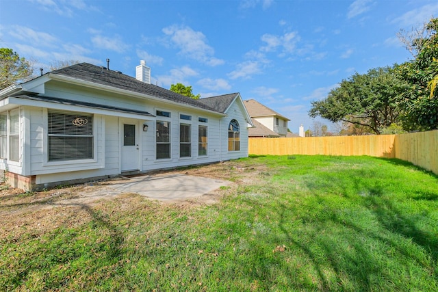 back of property with a lawn and a patio area