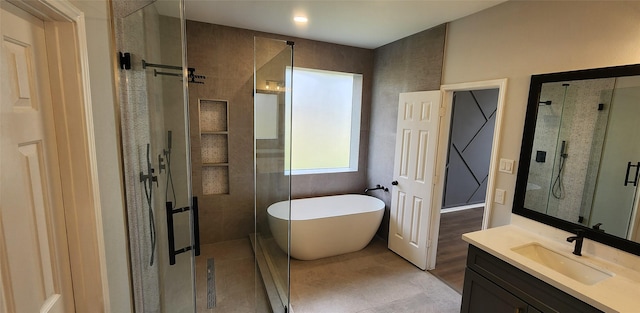 bathroom with vanity and shower with separate bathtub