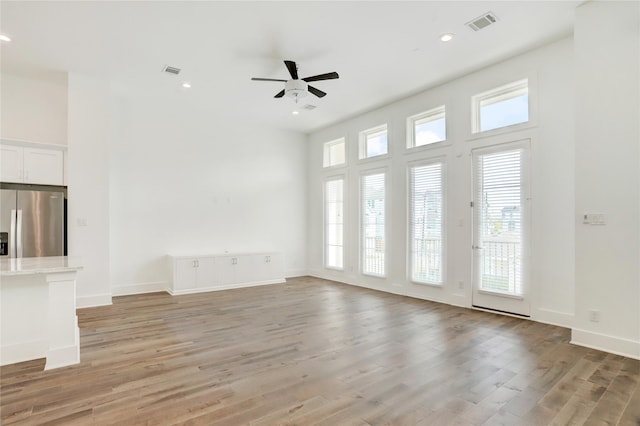 unfurnished living room with ceiling fan and light hardwood / wood-style floors