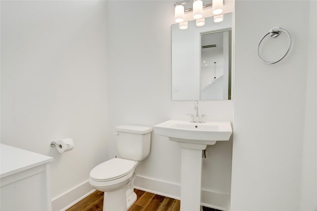 bathroom with hardwood / wood-style floors and toilet