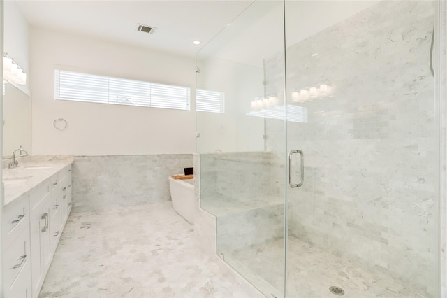 bathroom with separate shower and tub, vanity, and tile walls