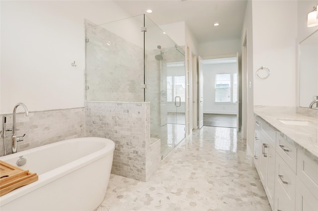 bathroom featuring vanity, separate shower and tub, and tile walls