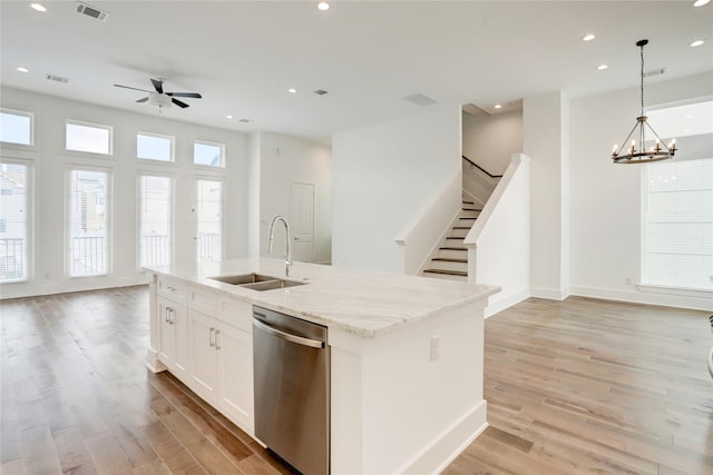 kitchen with dishwasher, a kitchen island with sink, white cabinets, sink, and decorative light fixtures