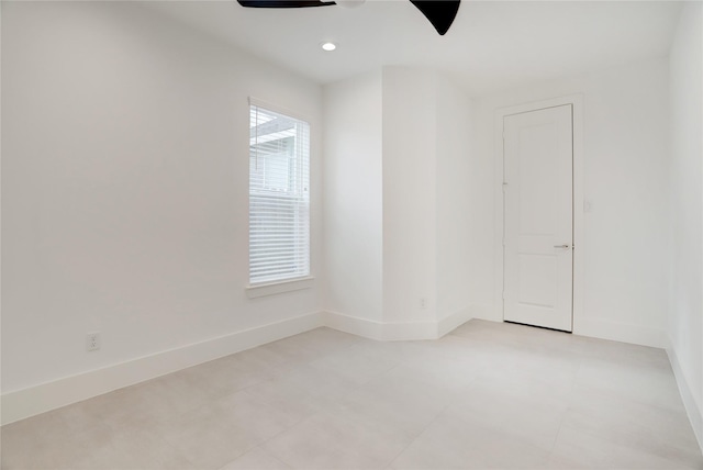 empty room with recessed lighting, a ceiling fan, and baseboards