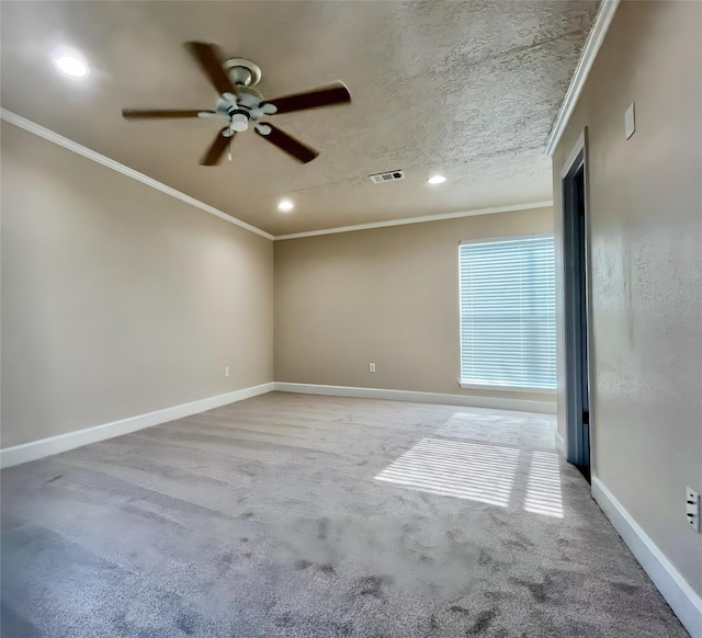 empty room with a textured ceiling, ceiling fan, carpet floors, and crown molding