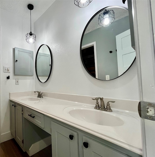 bathroom with hardwood / wood-style floors, vanity, and a textured ceiling