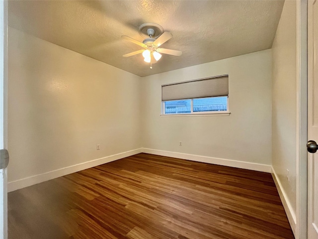 spare room with a textured ceiling, ceiling fan, and dark wood-type flooring