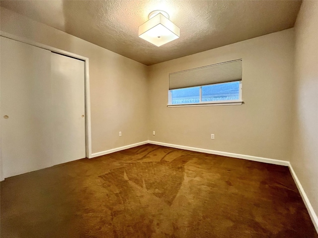 unfurnished bedroom with carpet flooring, a textured ceiling, and a closet