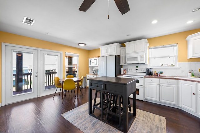 kitchen with backsplash, white cabinetry, ceiling fan, and white appliances