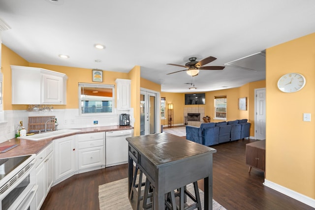 kitchen featuring white cabinets, white dishwasher, tasteful backsplash, and ceiling fan