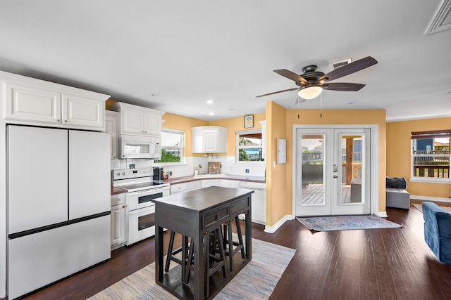 kitchen with white appliances, french doors, white cabinets, decorative backsplash, and a healthy amount of sunlight