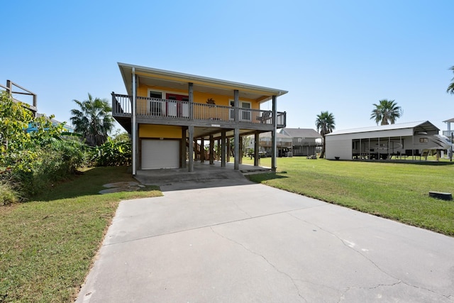 beach home featuring a front lawn, a garage, and a carport