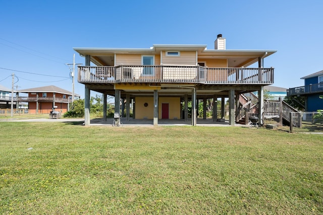 rear view of house featuring a patio, a deck, and a lawn