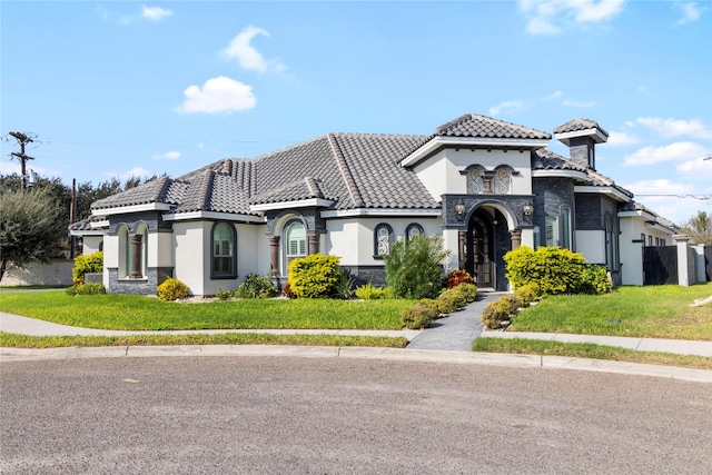 mediterranean / spanish home with a front lawn