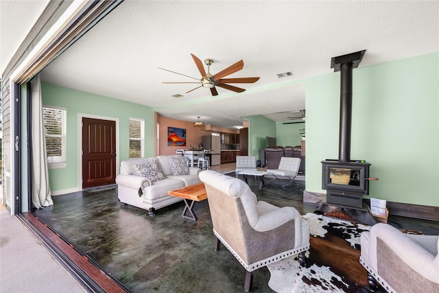 living room featuring a wood stove and a textured ceiling