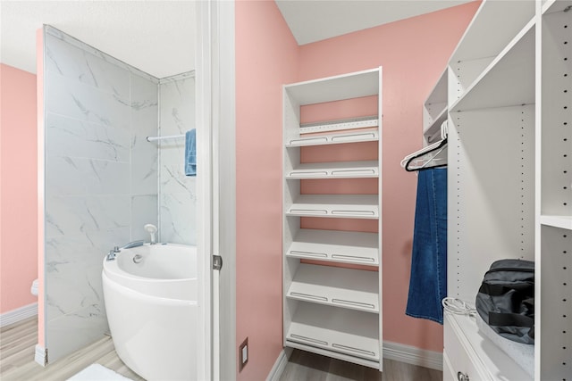 bathroom with a washtub and hardwood / wood-style floors