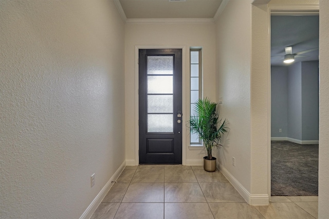 tiled entryway with plenty of natural light, crown molding, and ceiling fan