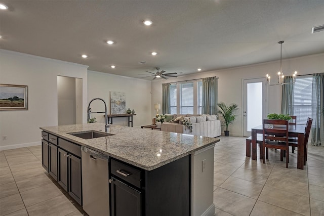 kitchen featuring stainless steel dishwasher, ceiling fan with notable chandelier, sink, hanging light fixtures, and an island with sink