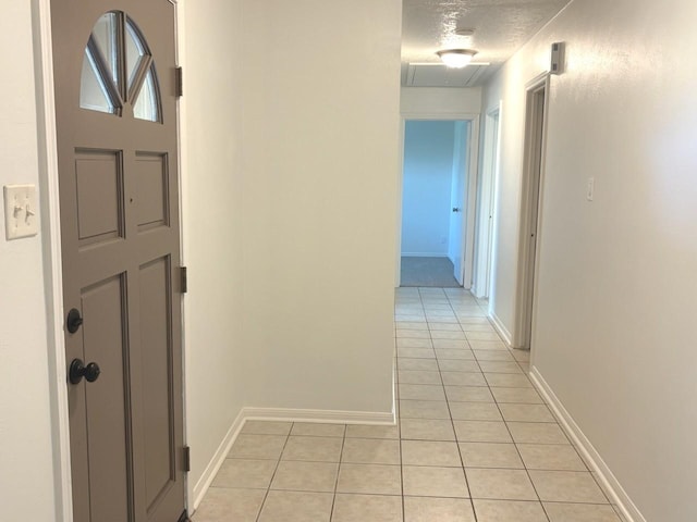 hall with light tile patterned floors and a textured ceiling