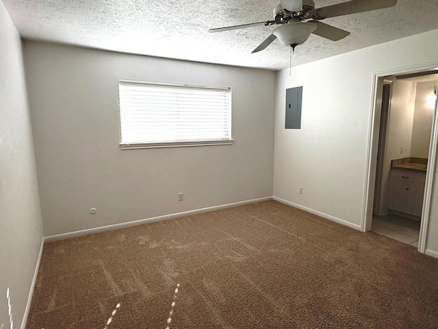 unfurnished bedroom with carpet flooring, ensuite bath, ceiling fan, electric panel, and a textured ceiling