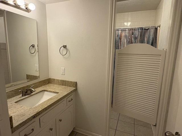 bathroom with a textured ceiling, vanity, tile patterned floors, and curtained shower