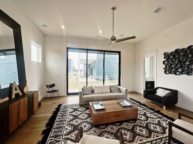 living room with ceiling fan and light hardwood / wood-style flooring