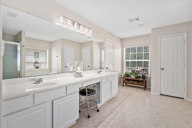 bathroom with vanity and a shower with door