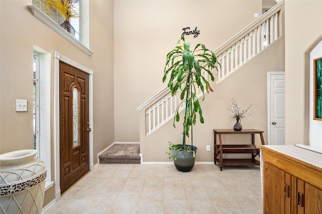 foyer with a high ceiling and light tile patterned floors