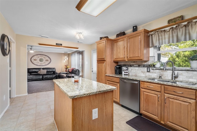 kitchen with dishwasher, a center island, light stone countertops, and sink