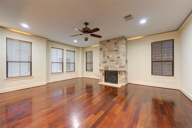 unfurnished living room featuring ceiling fan, crown molding, a fireplace, and dark wood-type flooring