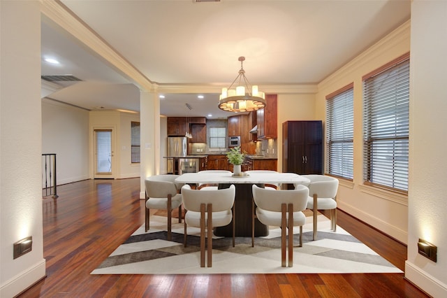 dining area featuring crown molding, dark wood-type flooring, and a notable chandelier