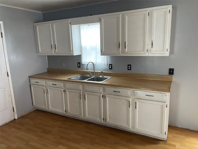 kitchen featuring sink, white cabinets, and light wood-type flooring