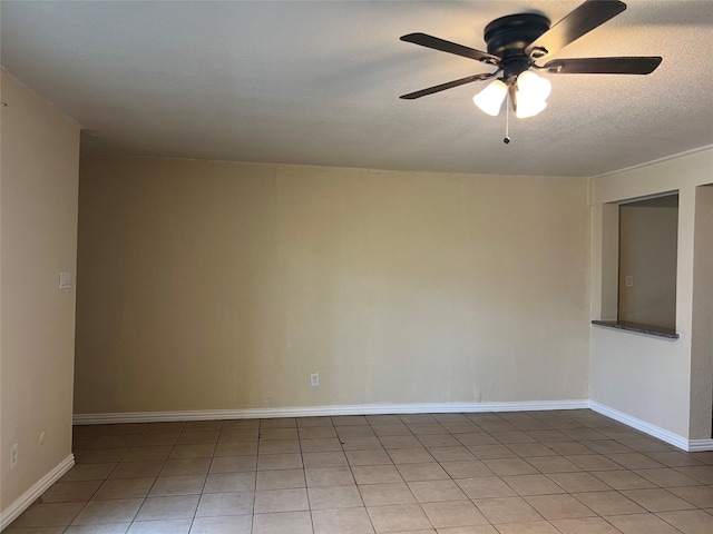 empty room with ceiling fan, tile patterned flooring, and a textured ceiling