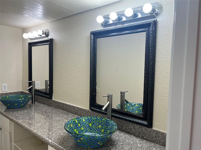 bathroom featuring a textured ceiling and vanity