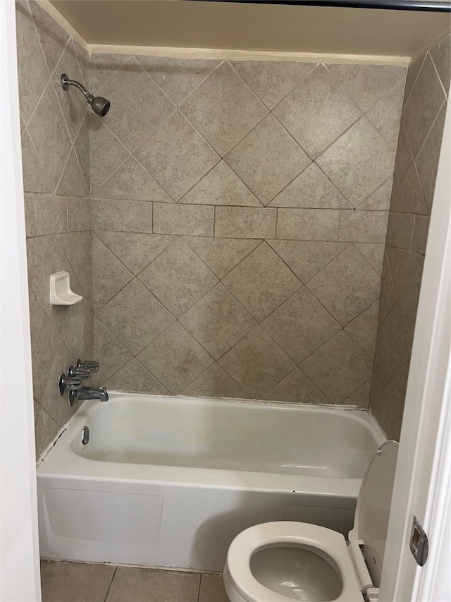 bathroom featuring tile patterned flooring, tiled shower / bath, and toilet