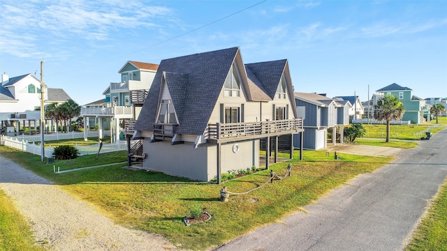 view of side of home with a lawn and a balcony