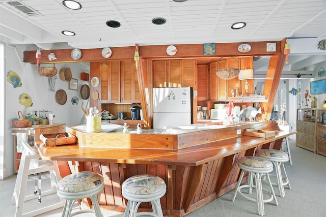 kitchen featuring light carpet, white refrigerator, and sink