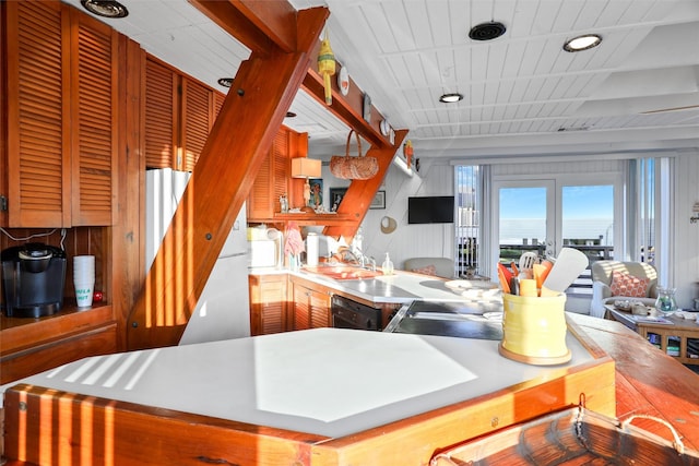 kitchen with beamed ceiling, black dishwasher, wood ceiling, and sink