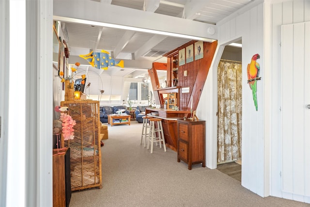 interior space featuring carpet flooring, wood walls, and beam ceiling